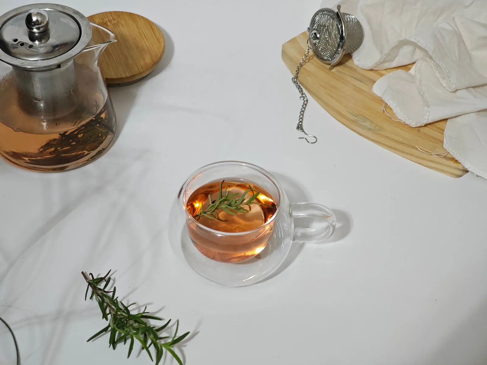 A glass teapot and a cup of brewed tea on a white table, representing private label beverages made by OEM drink manufacturers in Malaysia