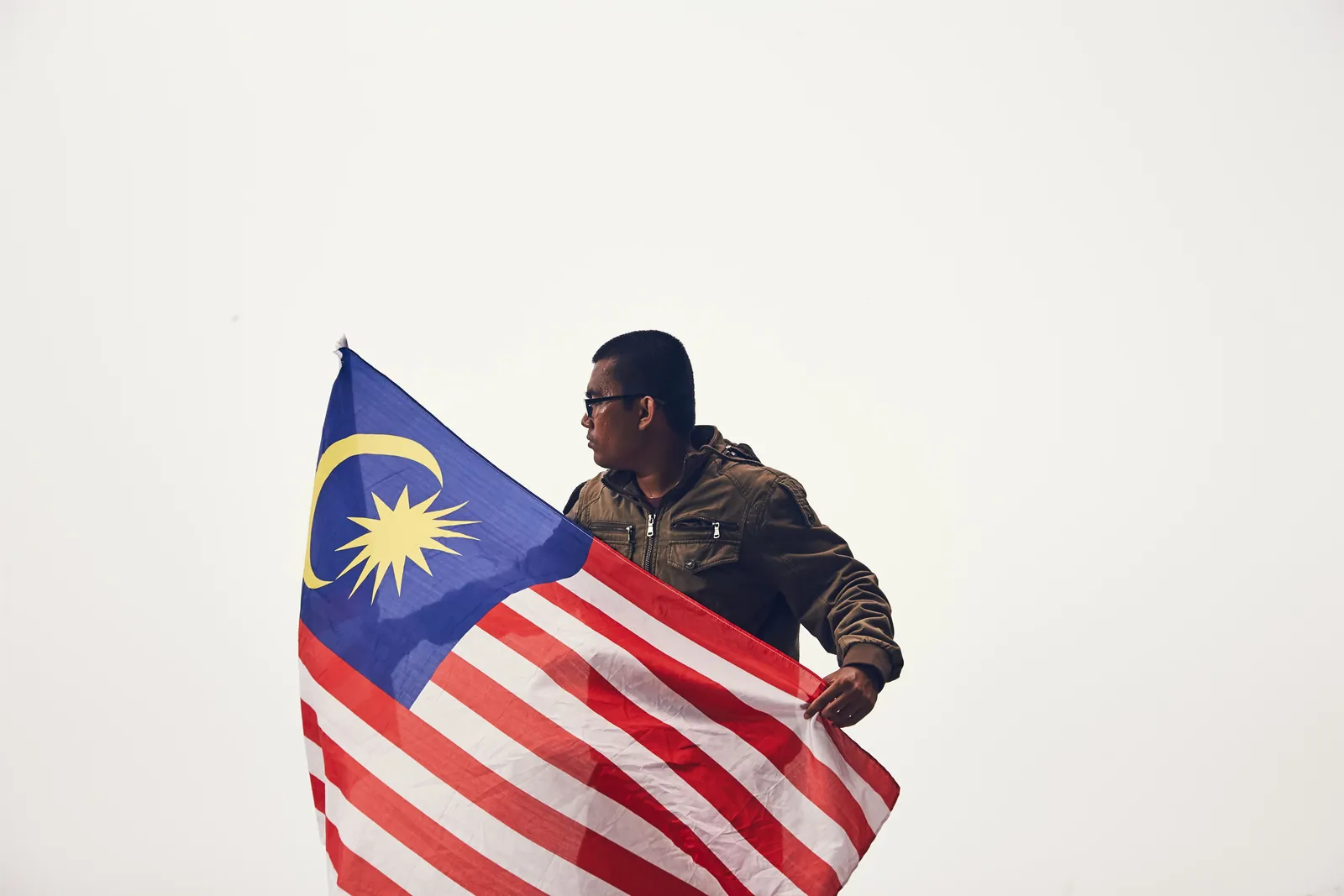 A person holding the Malaysian flag